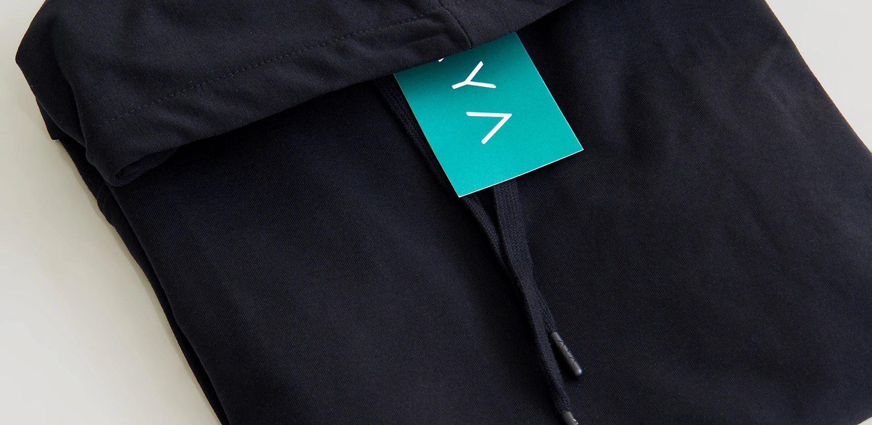 Black garment with a green tag on a white background