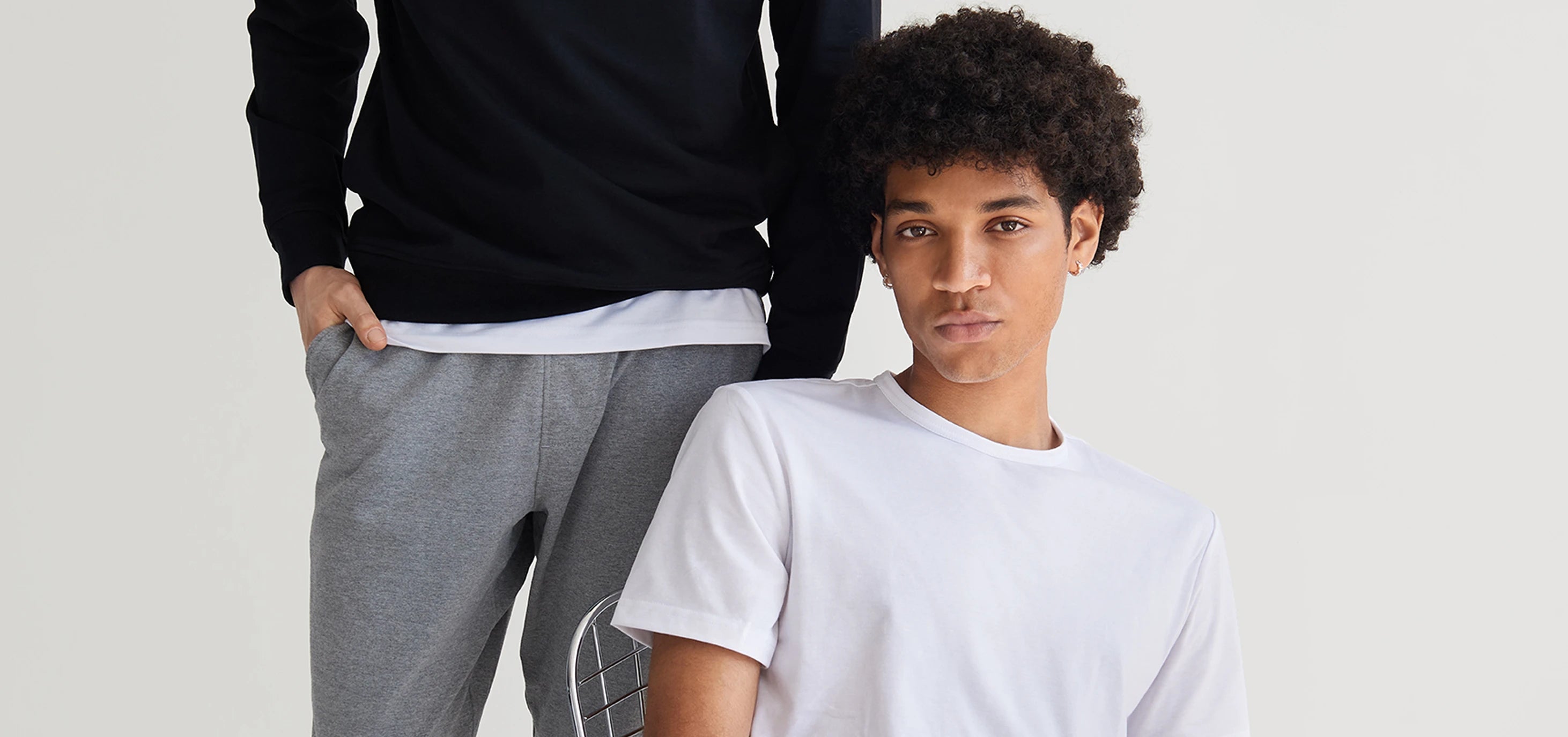 Two people wearing casual clothing against a plain background