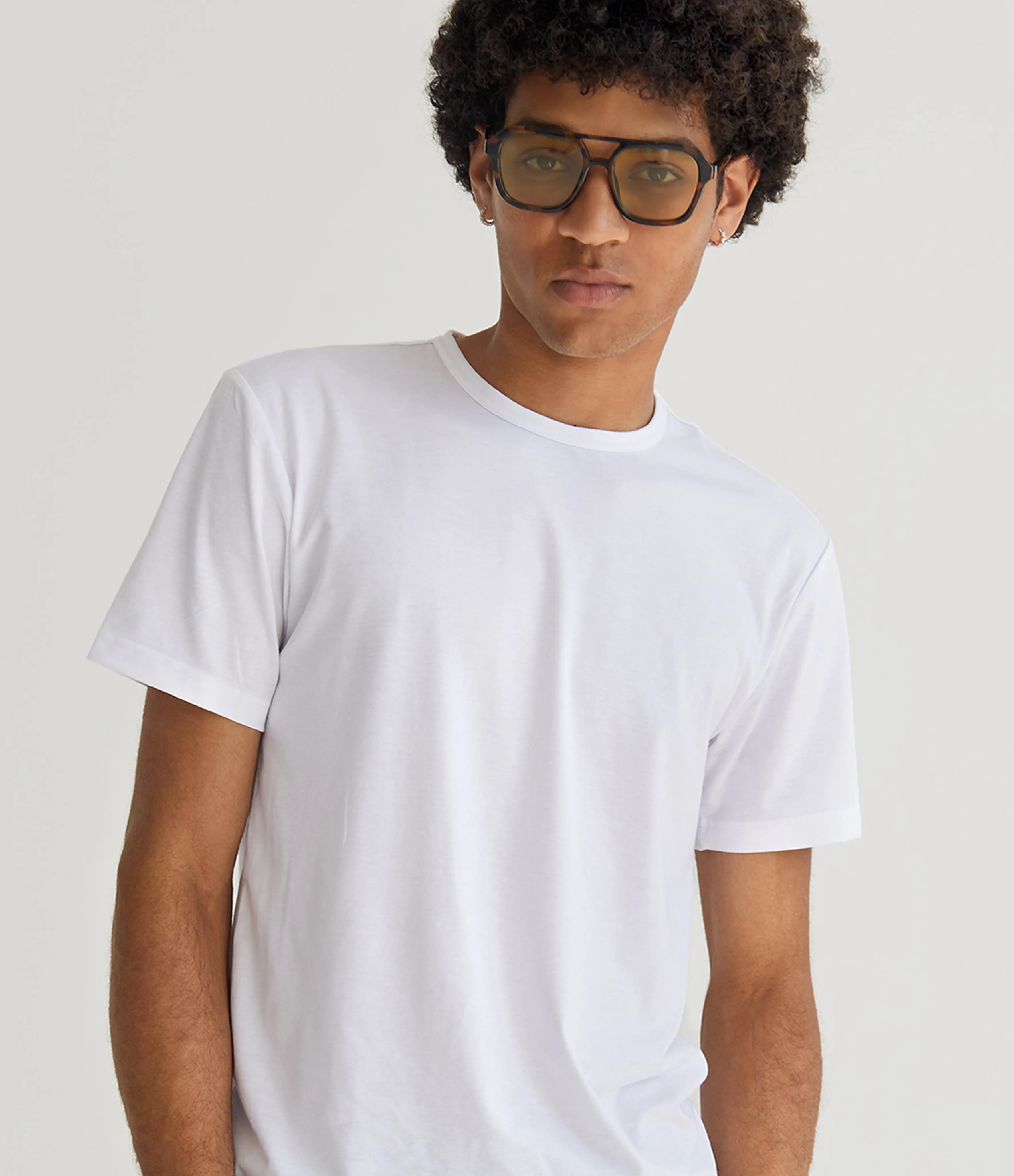 Person wearing a plain white t-shirt against a light background