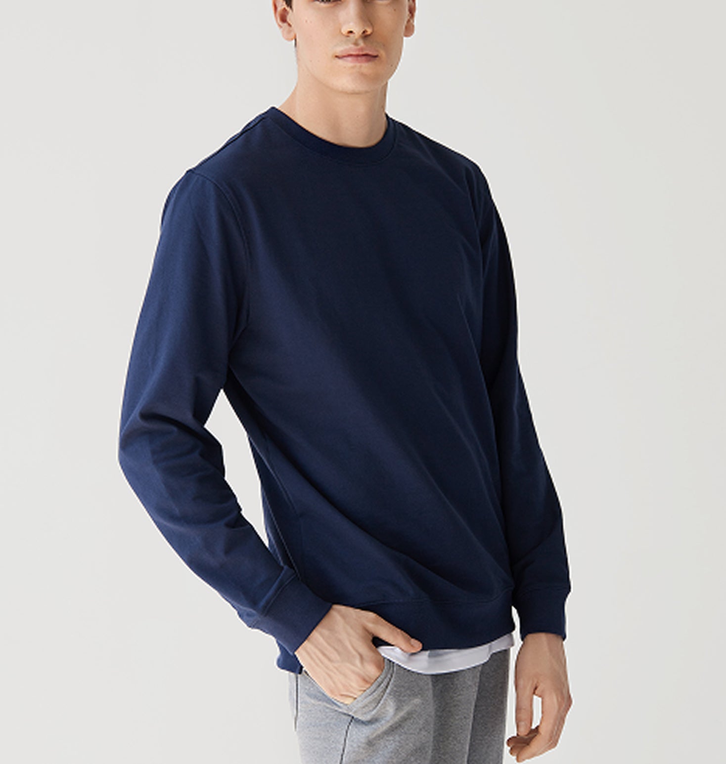 Man wearing a navy long-sleeve shirt on a light gray background