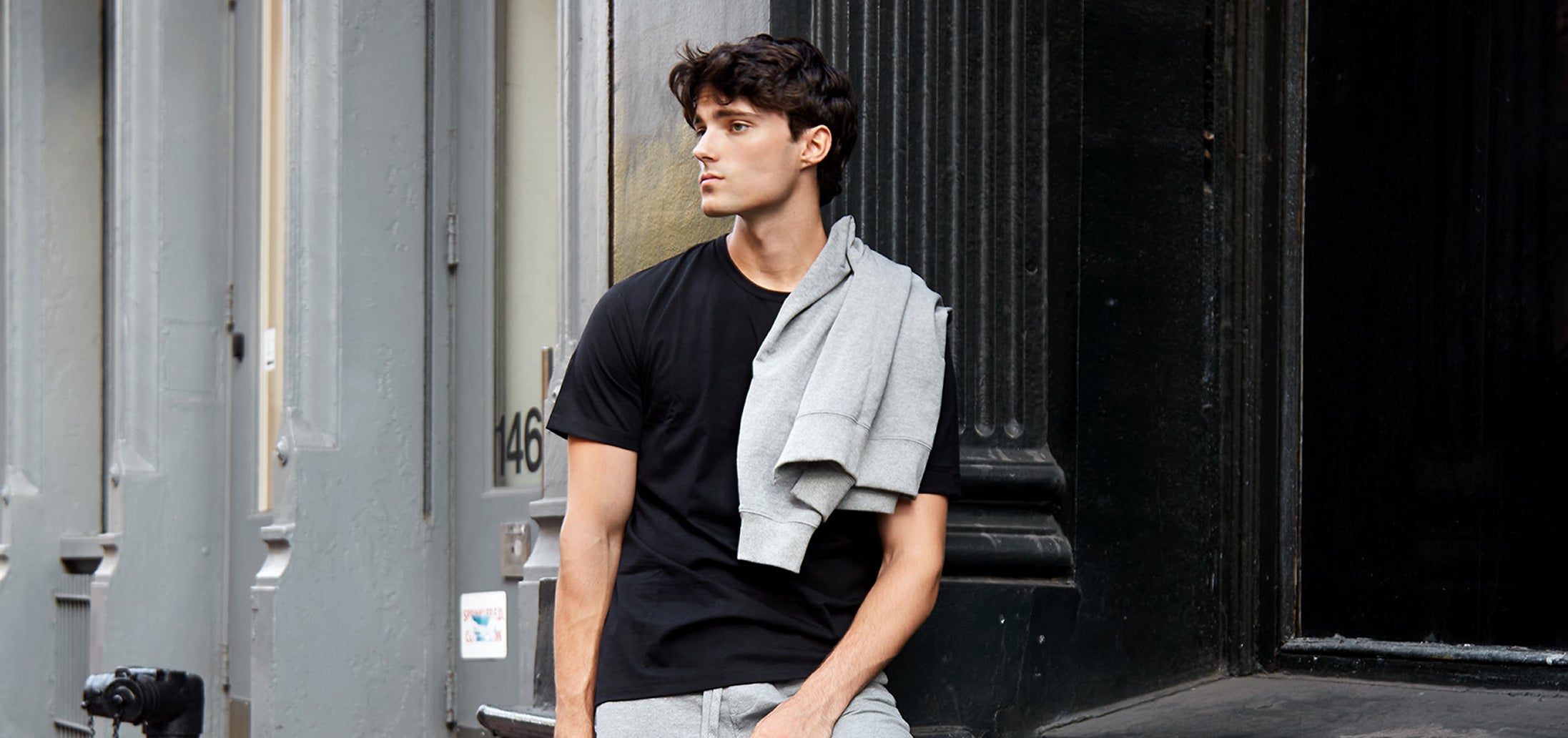 Man sitting outdoors with a towel draped over his shoulder